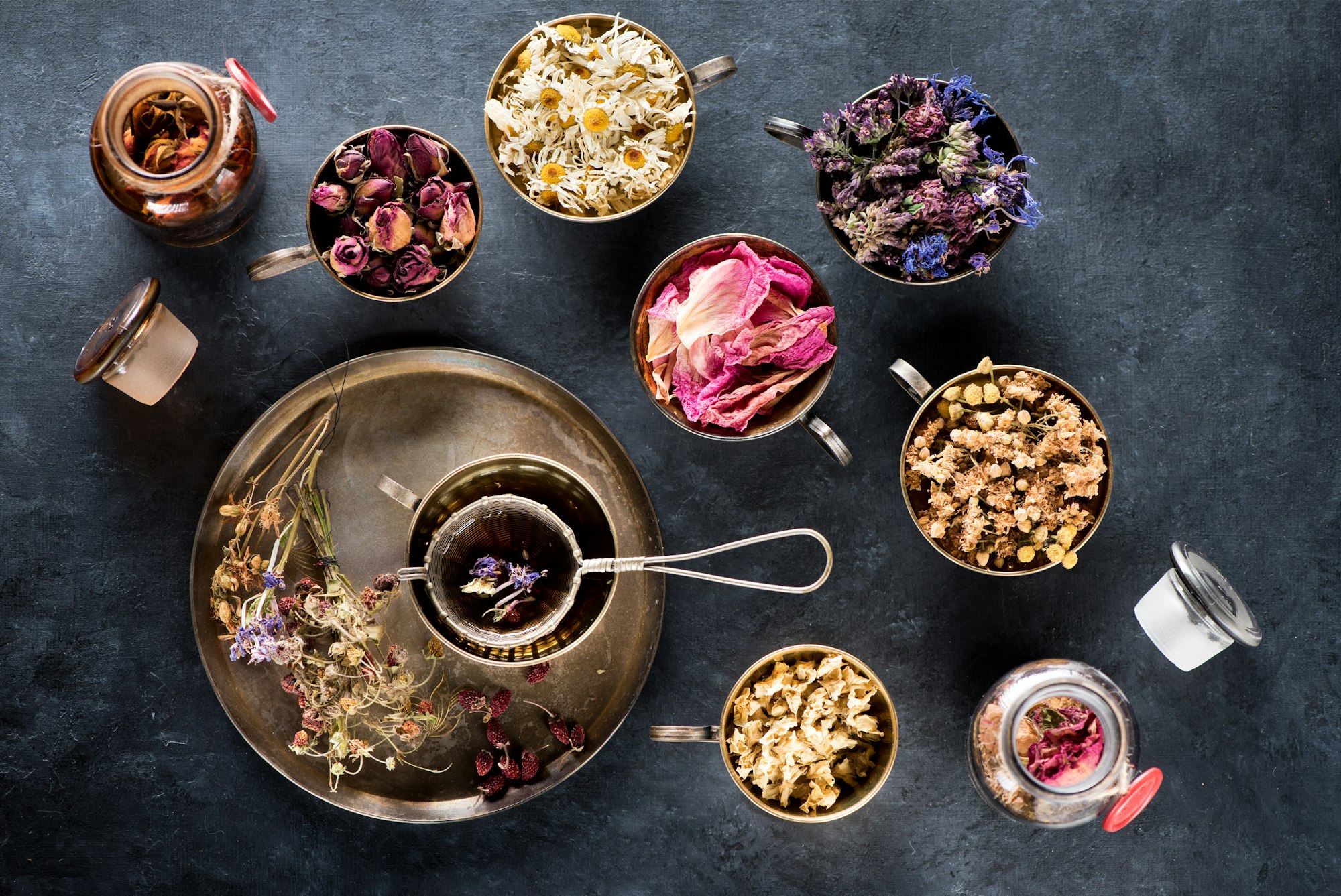 Dried medical healing herbs and herbal tea in metal cups